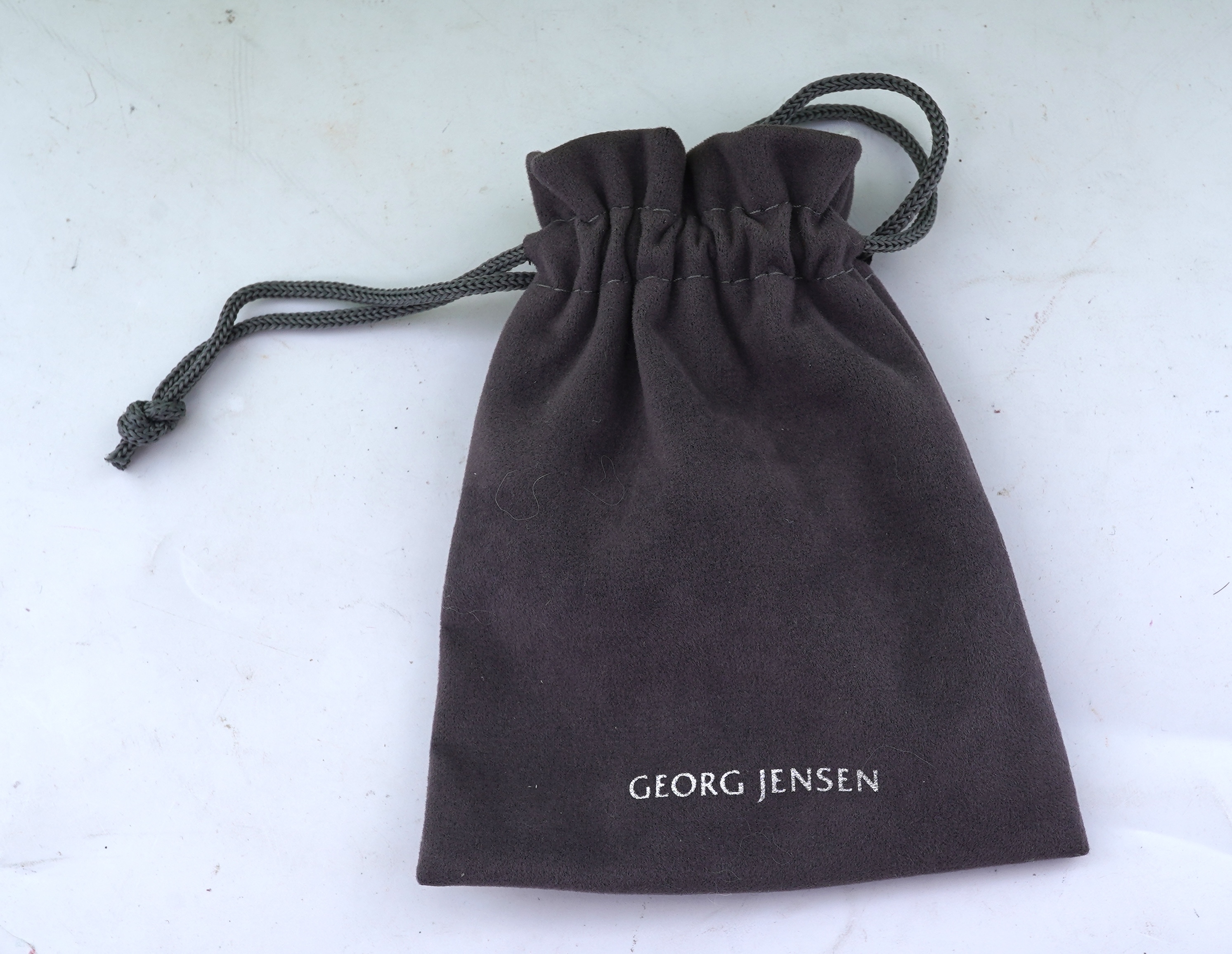 Georg Jensen, a blue topaz necklace, centring on a hook clasp suspending an oval blue topaz pendant, pendant length 5.5cm, necklace length 43cm, stamped GJ for Georg Jensen, 925S and European convention assay marks for s